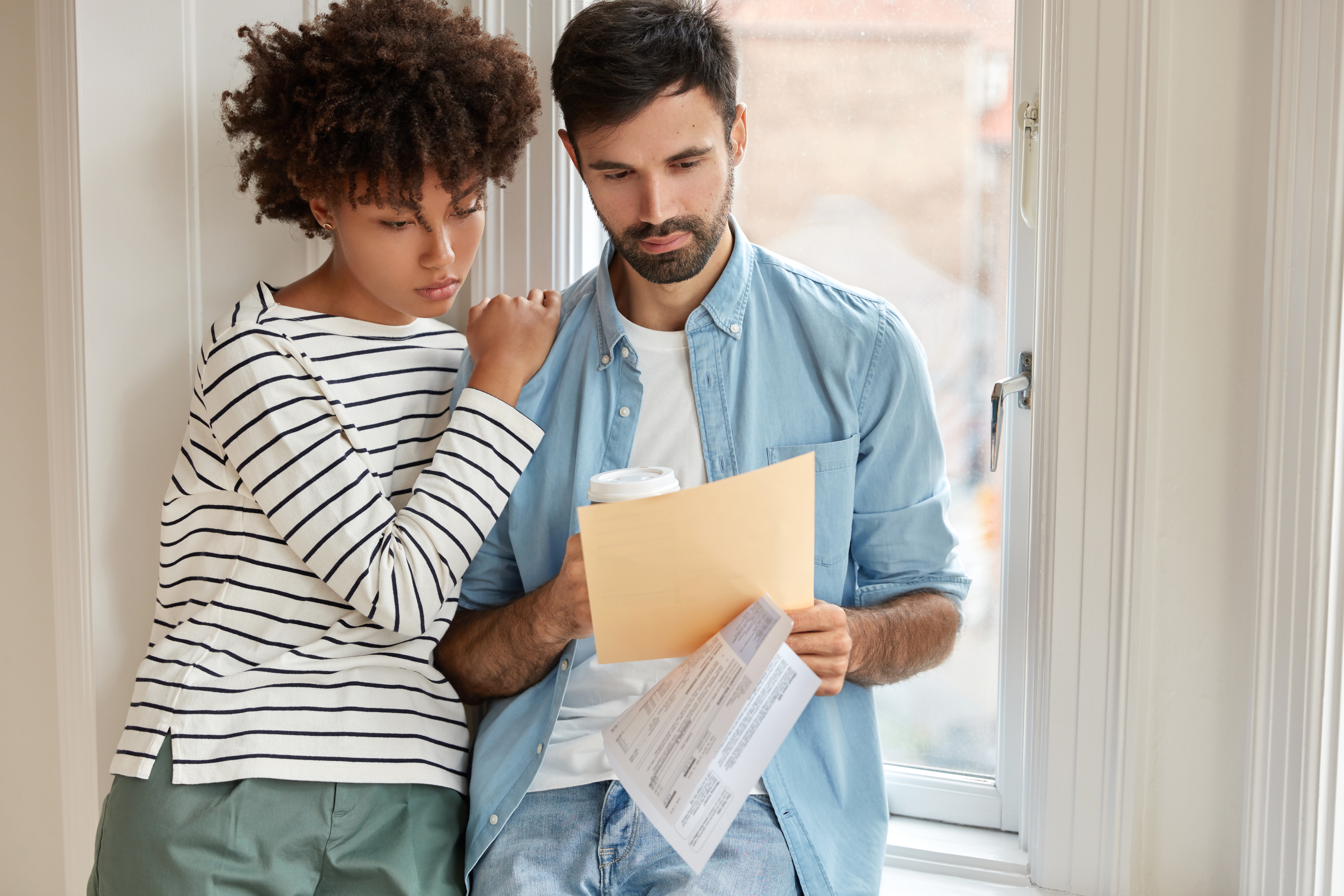 Imagen de pareja mirando un documento con preocupación