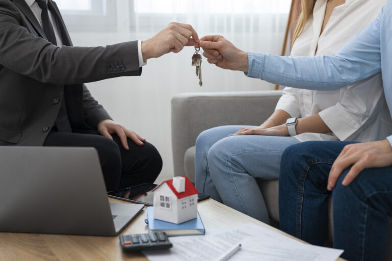 Agente inmobiliario dandole las llaves de la casa a una pareja plano de frente sin oder verse las caras